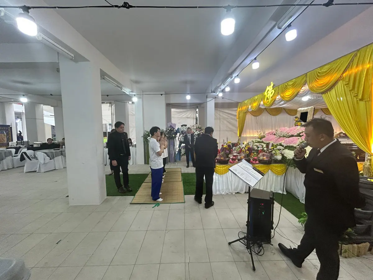 Family and funeral director during a Buddhist funeral service