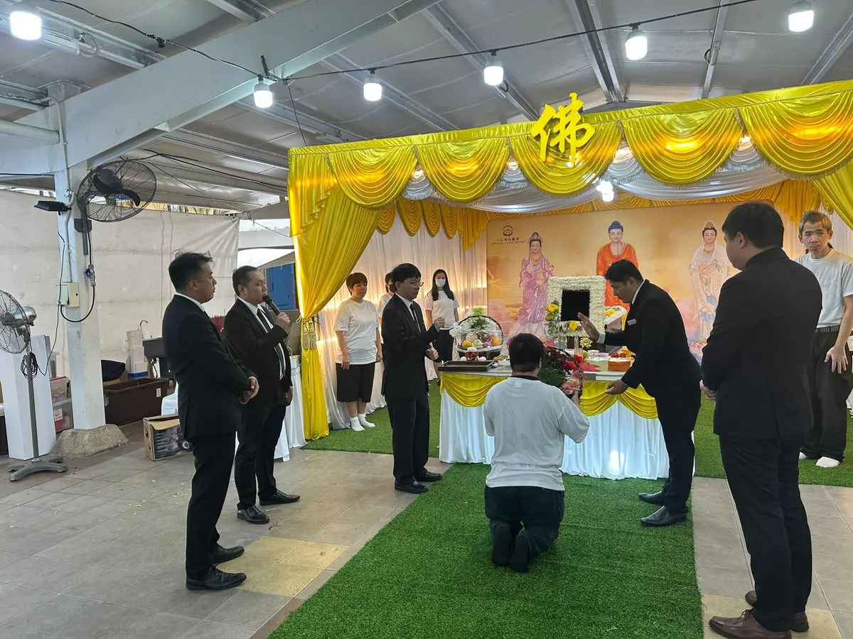 Family kneeling during Buddhist funeral prayers