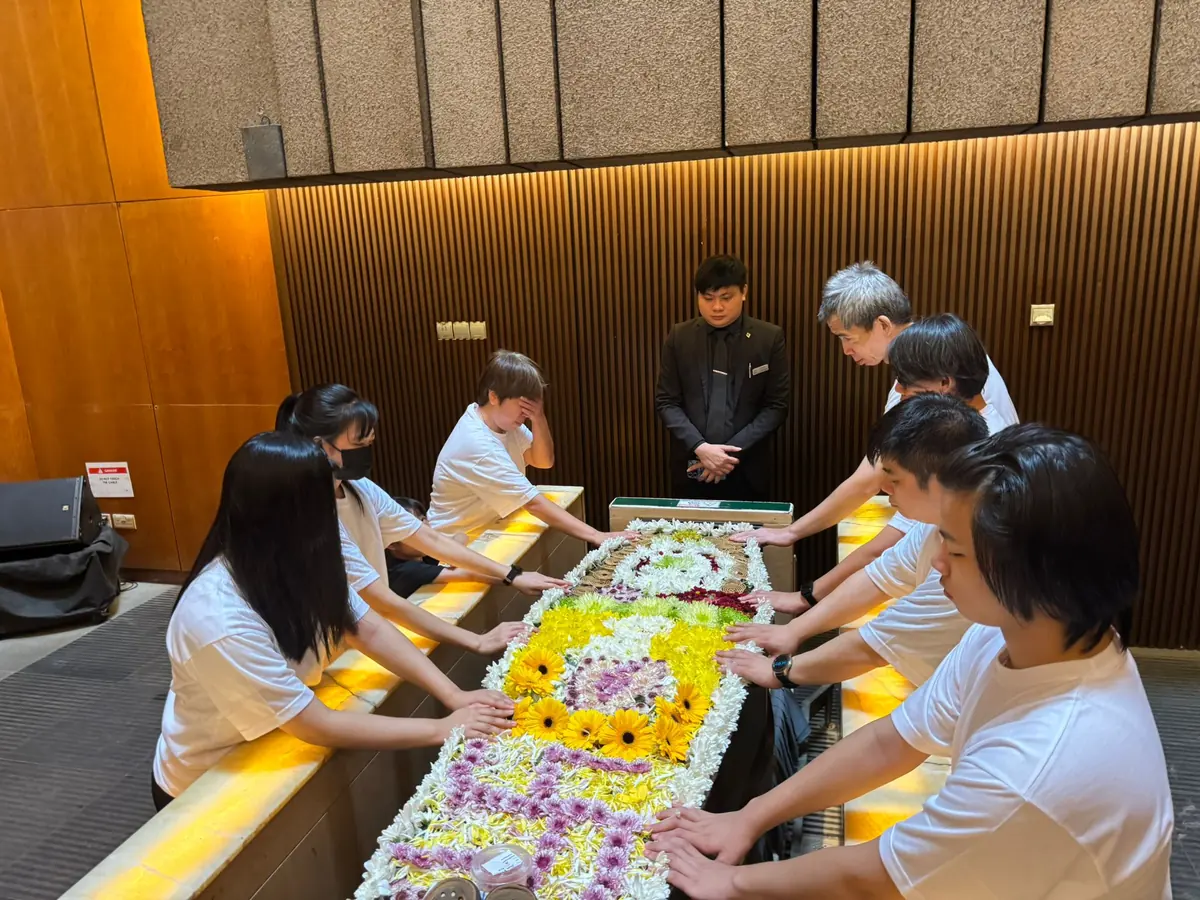 Family performing final Buddhist prayers at the casket